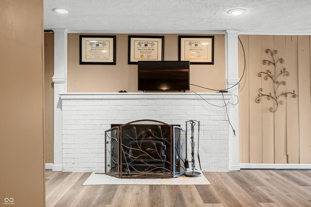 242 W Warford Dr, Princes Lakes, IN 46164 - detailed view of a textured ceiling, wood finished floors, baseboards, and a brick fireplace