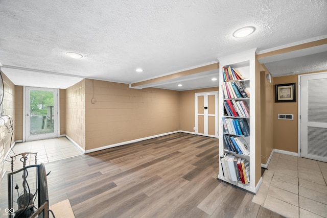 242 W Warford Dr, Princes Lakes, IN 46164 - below grade area featuring a textured ceiling, wood finished floors, french doors, baseboards, and concrete block wall