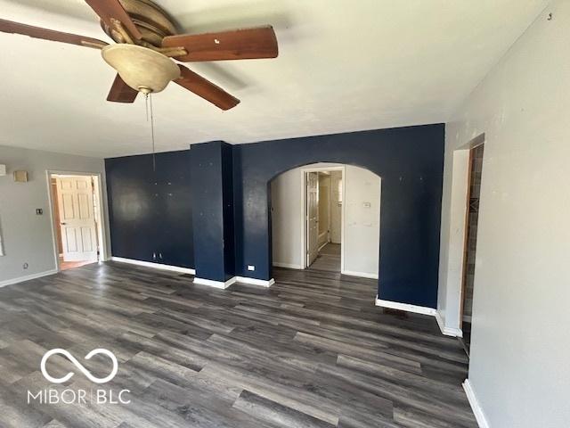 1527 Main St, Beech Grove, IN 46107 - spare room with arched walkways, a ceiling fan, dark wood-style flooring, and baseboards