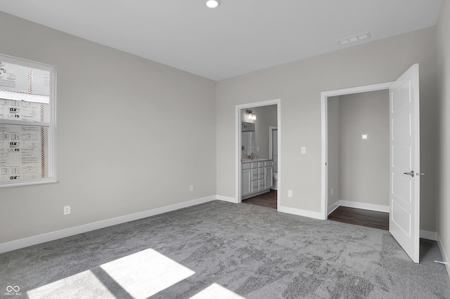 633 Bridgeman Rd, Avon, IN 46123 - unfurnished bedroom with dark carpet, baseboards, and ensuite bathroom