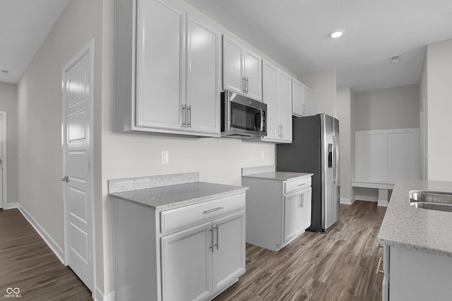 633 Bridgeman Rd, Avon, IN 46123 - kitchen featuring stainless steel appliances, dark wood-style floors, light stone countertops, white cabinets, and baseboards