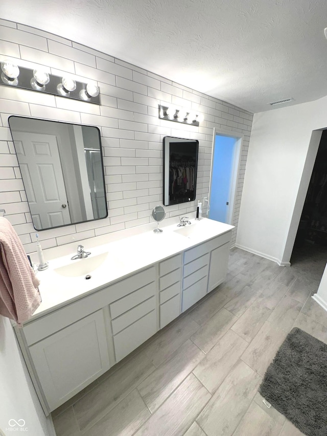 1056 Bent Branch Ln, Greenwood, IN 46143 - full bath with double vanity, wood finished floors, a textured ceiling, and baseboards