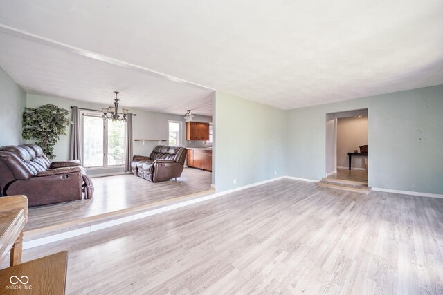2544 N E Raintree Dr, New Castle, IN 47362 - unfurnished living room with a chandelier and light wood-style flooring
