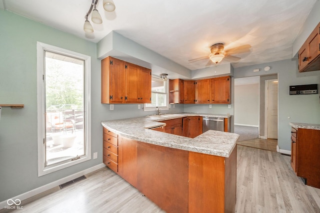 2544 N E Raintree Dr, New Castle, IN 47362 - kitchen with brown cabinets, stainless steel dishwasher, a peninsula, and light countertops
