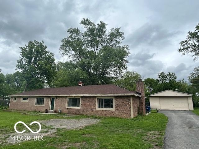 907 Monroe St, Indianapolis, IN 46229 - ranch-style house featuring a detached garage, an outbuilding, a front lawn, a chimney, and brick siding
