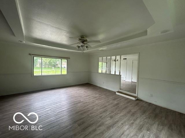907 Monroe St, Indianapolis, IN 46229 - unfurnished room with a tray ceiling, ceiling fan, wood finished floors, and baseboards