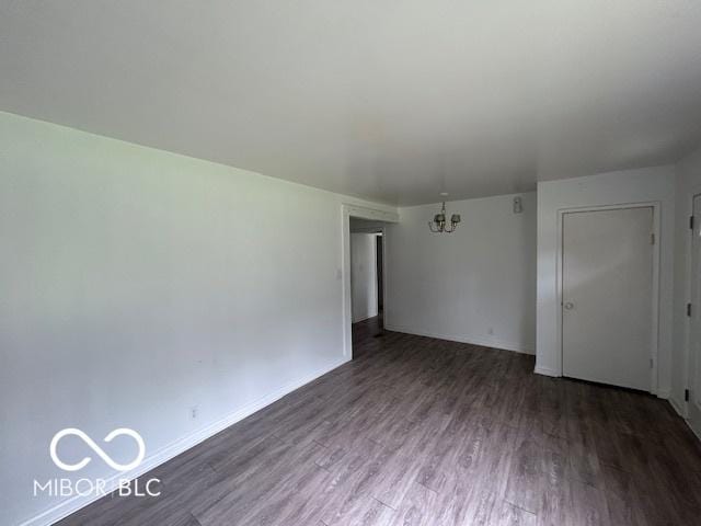 907 Monroe St, Indianapolis, IN 46229 - unfurnished room featuring wood finished floors, a chandelier, and baseboards