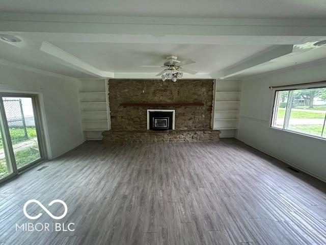 907 Monroe St, Indianapolis, IN 46229 - unfurnished living room featuring wood finished floors, a stone fireplace, a ceiling fan, and built in features