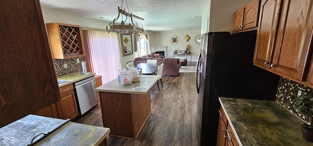 409 Spring Green Pl, Indianapolis, IN 46229 - kitchen featuring appliances with stainless steel finishes, dark wood finished floors, a fireplace, decorative backsplash, and a textured ceiling