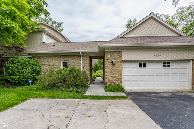 5326 White Marsh Ln, Indianapolis, IN 46226 - view of front of home featuring driveway, stone siding, roof with shingles, and a garage