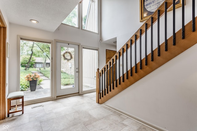 5326 White Marsh Ln, Indianapolis, IN 46226 - entrance foyer with healthy amount of natural light, stairs, a textured ceiling, a towering ceiling, and baseboards