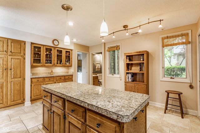 5326 White Marsh Ln, Indianapolis, IN 46226 - kitchen featuring brown cabinetry, light countertops, a kitchen island, and baseboards
