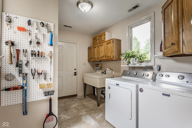 5326 White Marsh Ln, Indianapolis, IN 46226 - laundry area with washer and clothes dryer, cabinet space, a workshop area, a textured ceiling, and baseboards