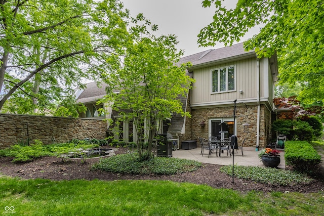 5326 White Marsh Ln, Indianapolis, IN 46226 - rear view of house with stone siding, a patio, and board and batten siding