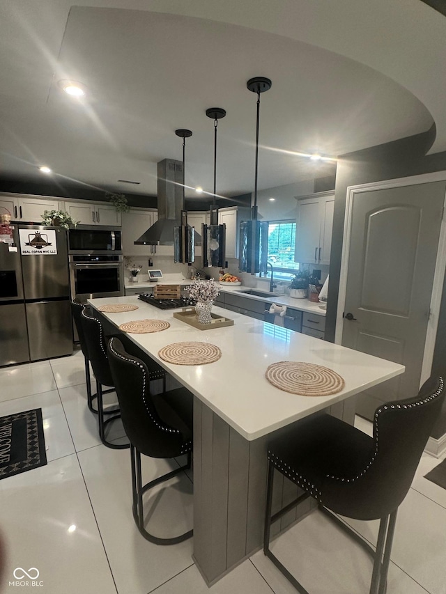 9527 Pepperidge Dr, Indianapolis, IN 46235 - kitchen featuring appliances with stainless steel finishes, island range hood, light countertops, a sink, and a breakfast bar area