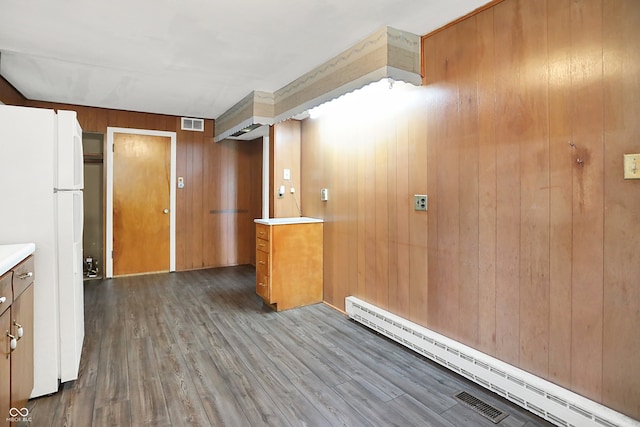 6580 N US Highway 31, Whiteland, IN 46184 - kitchen featuring freestanding refrigerator, a baseboard heating unit, wooden walls, wood finished floors, and light countertops