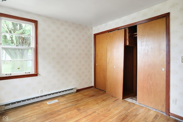 6580 N US Highway 31, Whiteland, IN 46184 - unfurnished bedroom featuring light wood finished floors, a closet, and a baseboard heating unit
