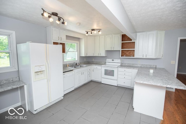1440 N County Road 275 E, North Vernon, IN 47265 - kitchen with white appliances, a peninsula, a sink, a textured ceiling, and plenty of natural light