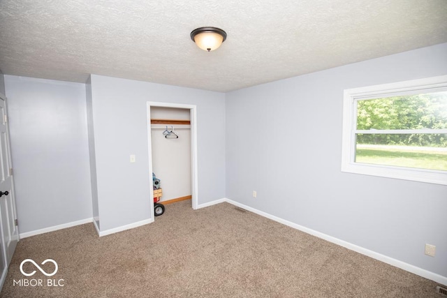 1440 N County Road 275 E, North Vernon, IN 47265 - unfurnished bedroom with carpet floors, a textured ceiling, baseboards, and a closet