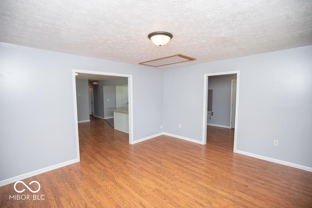 1440 N County Road 275 E, North Vernon, IN 47265 - empty room with wood finished floors, baseboards, and a textured ceiling