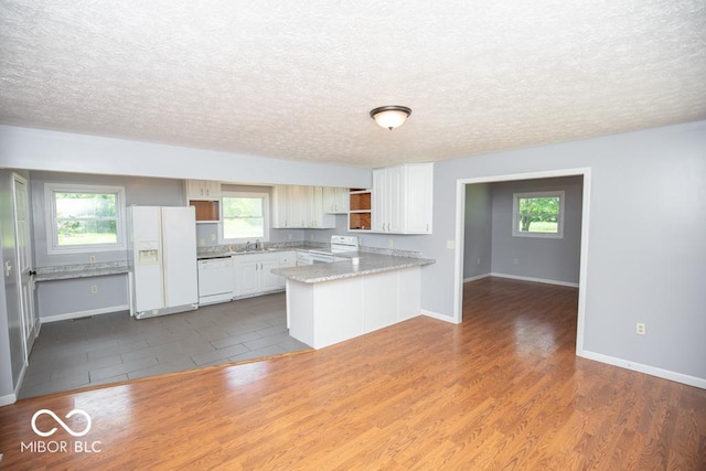 1440 N County Road 275 E, North Vernon, IN 47265 - kitchen featuring white appliances, a peninsula, a sink, a textured ceiling, and baseboards