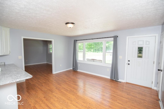 1440 N County Road 275 E, North Vernon, IN 47265 - unfurnished dining area featuring a textured ceiling, light wood-style flooring, and baseboards