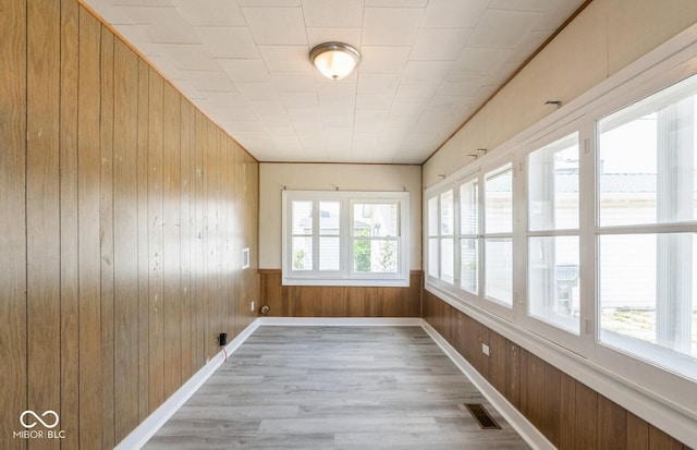 126 W Windsor St, Montpelier, IN 47359 - unfurnished sunroom featuring wood walls, wood finished floors, and baseboards