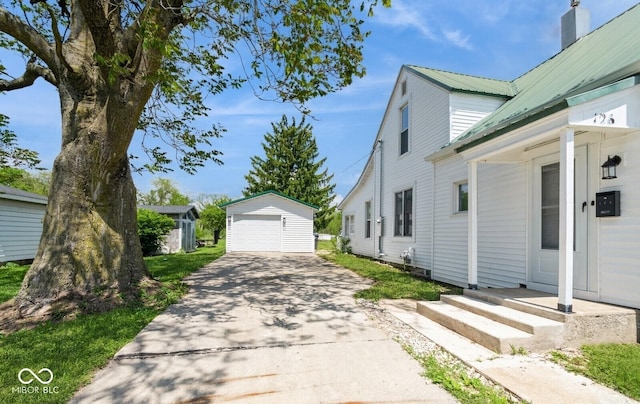 126 W Windsor St, Montpelier, IN 47359 - view of side of property with an outdoor structure, a garage, driveway, and metal roof
