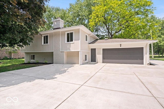 11123 Haverstick Rd, Carmel, IN 46033 - bi-level home featuring brick siding, concrete driveway, an attached garage, and a chimney
