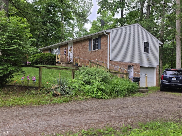 6305 W Hickory Hill Dr, North Vernon, IN 47265 - ranch-style home with an attached garage, brick siding, and dirt driveway