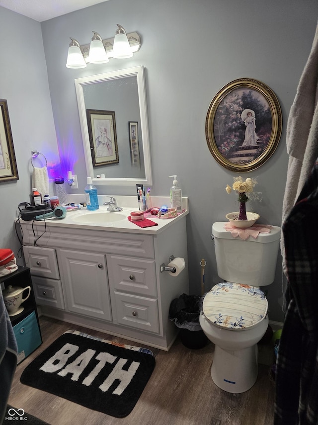 6305 W Hickory Hill Dr, North Vernon, IN 47265 - half bath with vanity, wood finished floors, and toilet