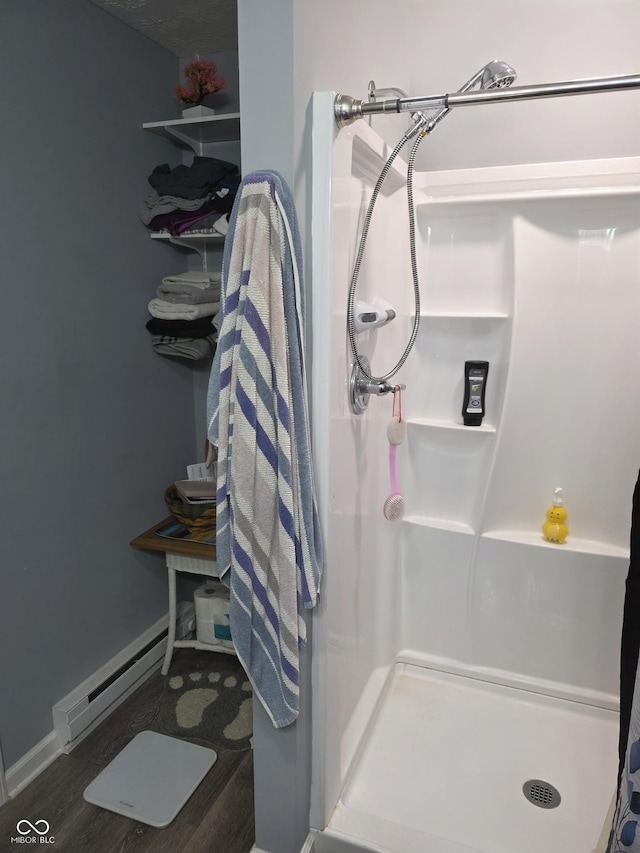 6305 W Hickory Hill Dr, North Vernon, IN 47265 - full bathroom with baseboard heating, a stall shower, wood finished floors, and baseboards