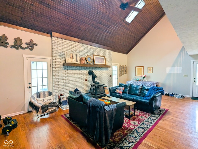 6336 N Carroll Rd, Indianapolis, IN 46235 - living room with high vaulted ceiling, a wood stove, baseboards, and wood finished floors