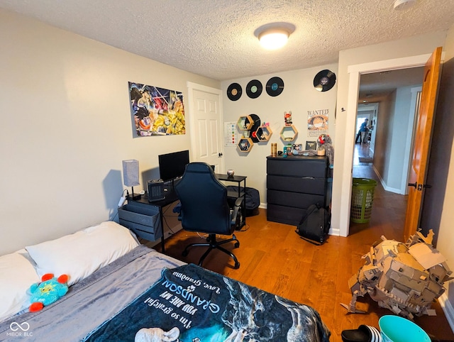 6336 N Carroll Rd, Indianapolis, IN 46235 - bedroom featuring wood finished floors, a textured ceiling, and baseboards
