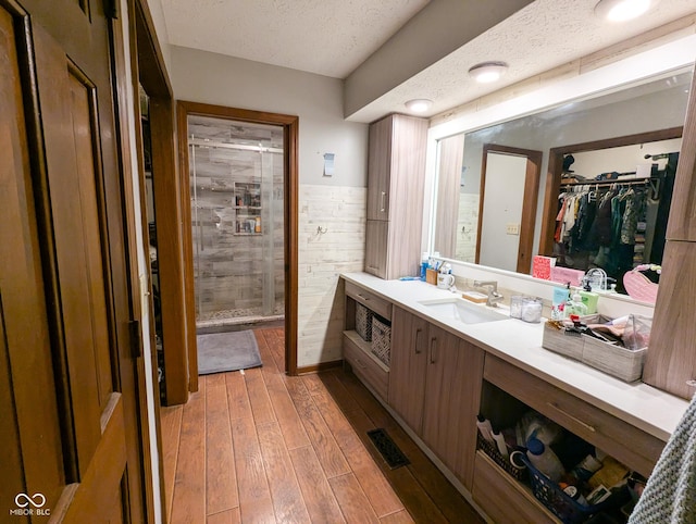 6336 N Carroll Rd, Indianapolis, IN 46235 - full bathroom with a stall shower, vanity, a walk in closet, a textured ceiling, and wainscoting