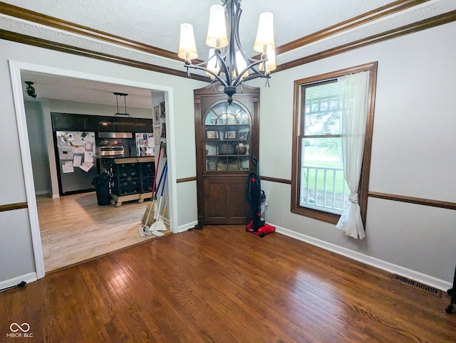 6336 N Carroll Rd, Indianapolis, IN 46235 - unfurnished dining area featuring a chandelier, wood finished floors, baseboards, ornamental molding, and a textured ceiling