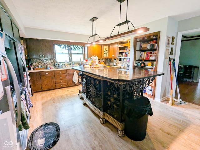 6336 N Carroll Rd, Indianapolis, IN 46235 - kitchen featuring light wood-type flooring, brown cabinetry, hanging light fixtures, and a center island