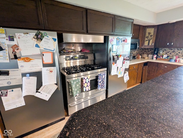 6336 N Carroll Rd, Indianapolis, IN 46235 - kitchen featuring stainless steel appliances, under cabinet range hood, tasteful backsplash, dark stone countertops, and glass insert cabinets