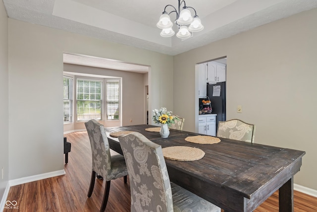 8376 Glen Highlands Dr, Indianapolis, IN 46236 - dining area featuring wood finished floors, baseboards, a chandelier, and a tray ceiling