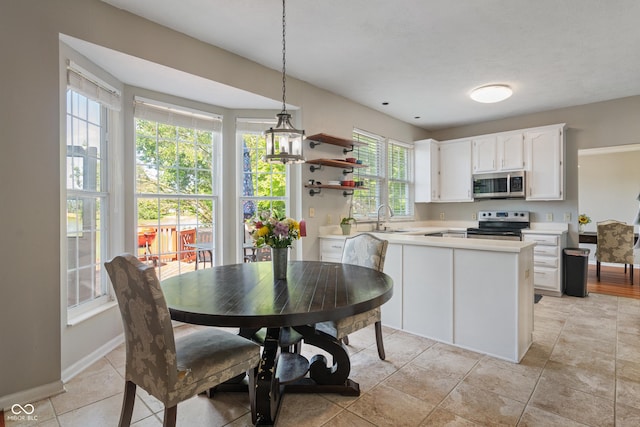 8376 Glen Highlands Dr, Indianapolis, IN 46236 - kitchen with appliances with stainless steel finishes, light countertops, white cabinetry, a sink, and hanging light fixtures