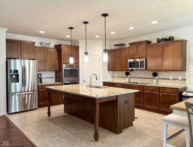 11700 Harvest Moon Dr, Noblesville, IN 46060 - kitchen featuring appliances with stainless steel finishes, crown molding, decorative backsplash, light stone counters, and a center island with sink
