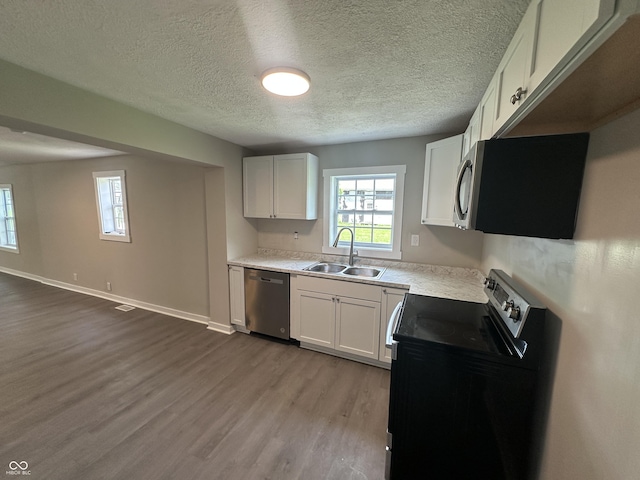 906 N Wabash Ave, Hartford City, IN 47348 - kitchen with stainless steel appliances, a sink, dark wood-type flooring, white cabinetry, and light countertops