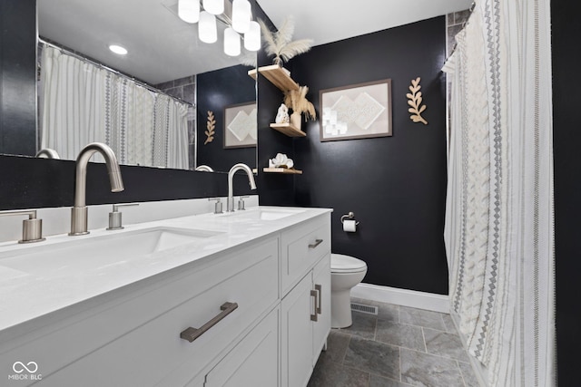 213 Terre Vista Dr, Terre Haute, IN 47803 - full bath featuring double vanity, toilet, baseboards, and stone finish flooring
