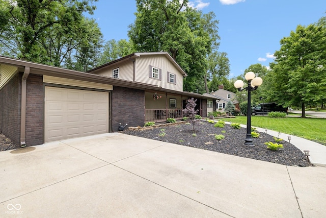 213 Terre Vista Dr, Terre Haute, IN 47803 - traditional-style home featuring covered porch, a garage, brick siding, concrete driveway, and a front yard