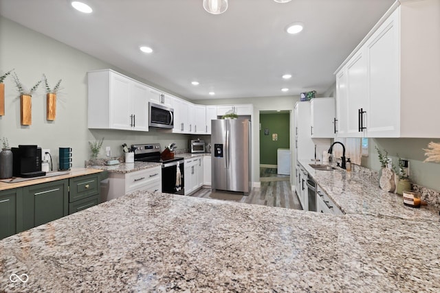 213 Terre Vista Dr, Terre Haute, IN 47803 - kitchen with appliances with stainless steel finishes, a sink, light stone countertops, recessed lighting, and white cabinetry