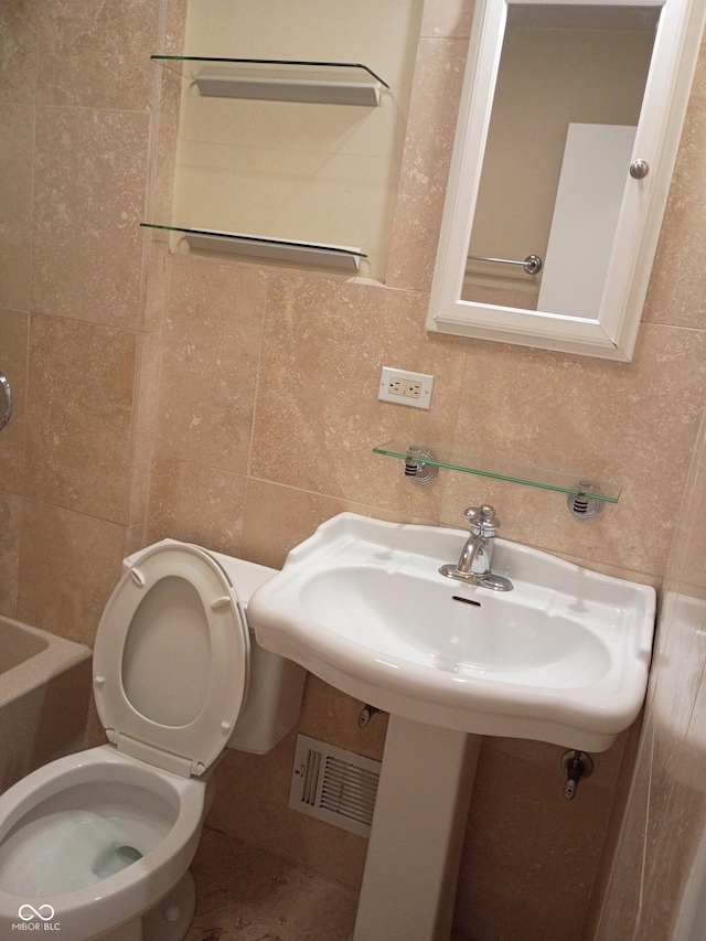 1008 E 61st St, Indianapolis, IN 46220 - bathroom with tile walls, toilet, and decorative backsplash
