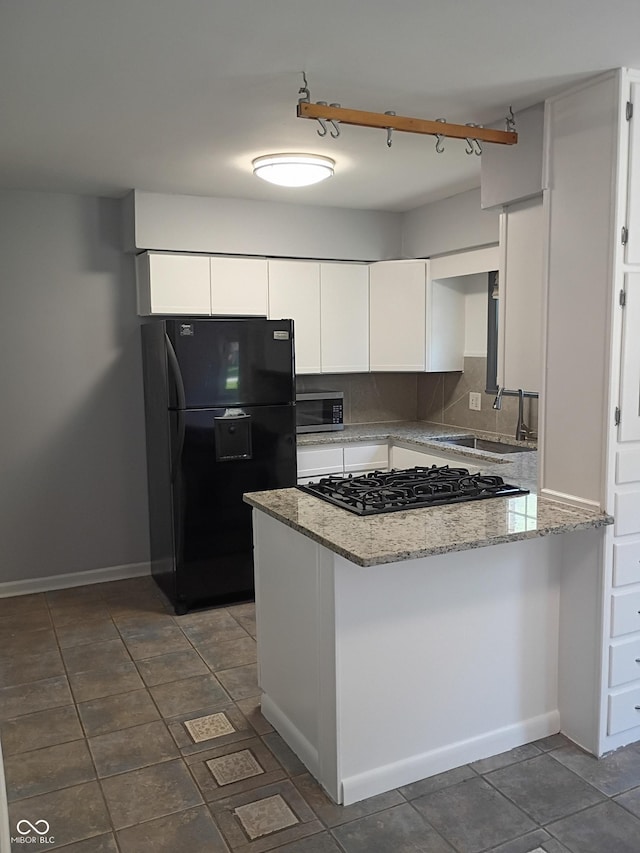 1008 E 61st St, Indianapolis, IN 46220 - kitchen with black appliances, a sink, a peninsula, white cabinetry, and light stone countertops