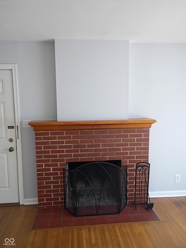 1008 E 61st St, Indianapolis, IN 46220 - detailed view of a brick fireplace, wood finished floors, and baseboards