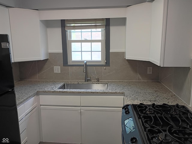 1008 E 61st St, Indianapolis, IN 46220 - kitchen with black appliances, a sink, white cabinetry, and tasteful backsplash