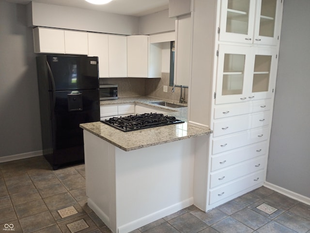 1008 E 61st St, Indianapolis, IN 46220 - kitchen featuring black appliances, a sink, a peninsula, baseboards, and white cabinetry